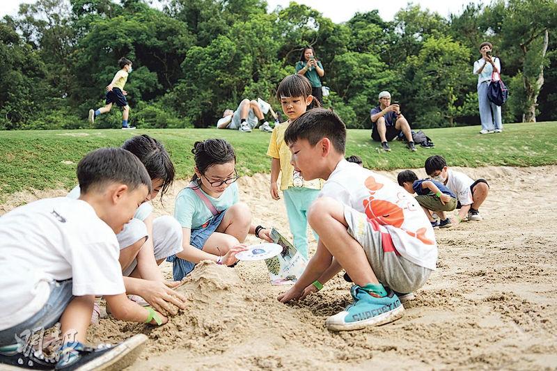 高球場內的沙池成為小朋友玩堆沙的「樂園」。（賴俊傑攝）