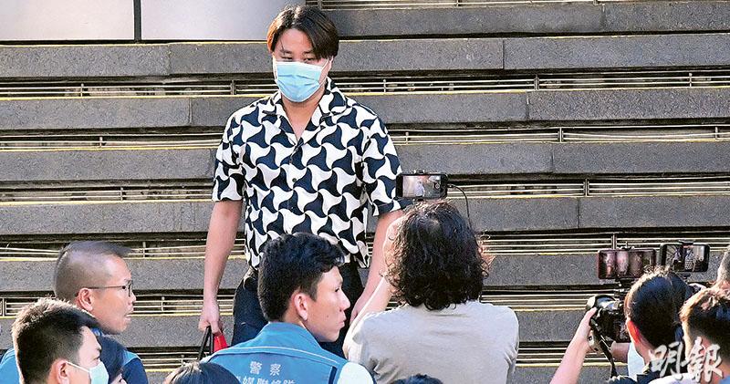 在海外籌組「香港議會」的袁弓夷正被警方國安處通緝，據悉其二子袁彌昌（面對鏡頭者）昨日被帶走協助調查。袁彌昌下午約5時半步出灣仔警察總部，隨即被大批等候多時的傳媒包圍，被問到有否披露父親行蹤，他回應稱「我可以點答啫……多謝關心」，其後登上的士離開。（劉焌陶攝）