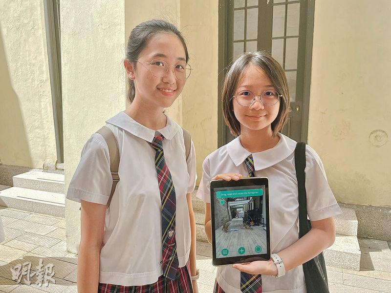 聖保祿學校學生石懷玥（右）同陳心喬（左）有份構思同製作以「打小人」文化為背景嘅AR模型「利魂繞」。（邱煒峰攝）