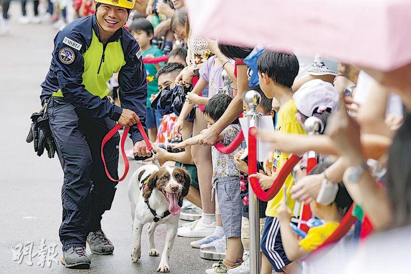 消防及救護車巡遊後，工作人員帶兩隻消防犬與市民近距離接觸。（楊柏賢攝）