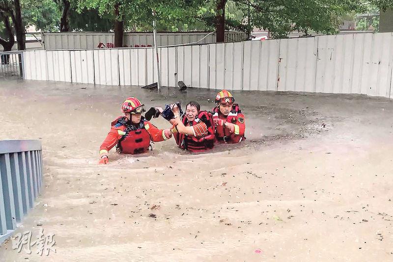 福建省廈門市受颱風影響，連日暴雨成災，救援人員前日救出被淹沒地區的一名居民。 （法新社）