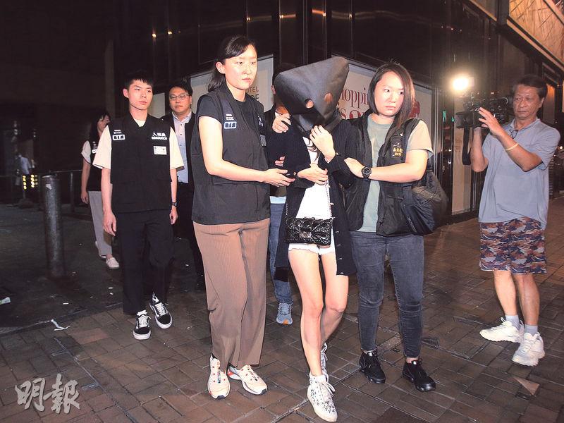 警方瓦解一個操控未成年少女的賣淫集團，拘捕10人，4人是日籍女子（黑布蒙頭者）。據悉被捕者包括一名來港賣淫的日本AV女優。（伍浦鋒攝）