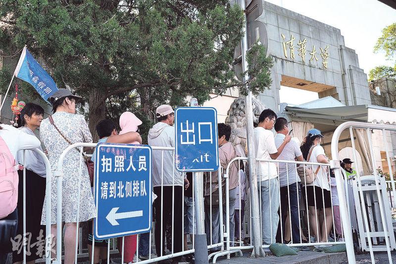 暑假期間，清華大學門外每天清晨已聚集幾十人排隊拍照，部分是隨團到訪的遊客，不少家長亦帶同子女到場。（鄧佾文攝）