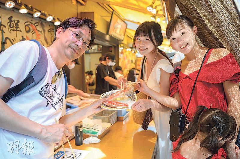 港人陳先生（左）與朋友兩戶人家月初訪日，到東京「築地場外市場」食蟹、生蠔及刺身等。他不擔心當地海鮮的食物安全受影響，反問「既然（當地人）相信日本政府，為何又會有問題？」（鄧宗弘攝）