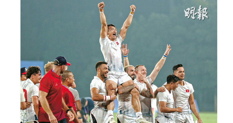 香港男子七人欖球隊昨於杭州亞運決賽挫韓國隊衛冕，丹馬克（右六）及虎拿當尼（右四）賽後抬起星將姚錦成（上）慶祝。（許嘉明攝）