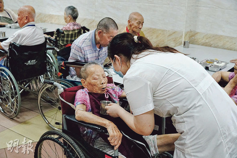 中午時分，肇慶福壽居頤養院員工為長者派飯。無法自行進食的長者，由護理員餵食。（林迎攝）