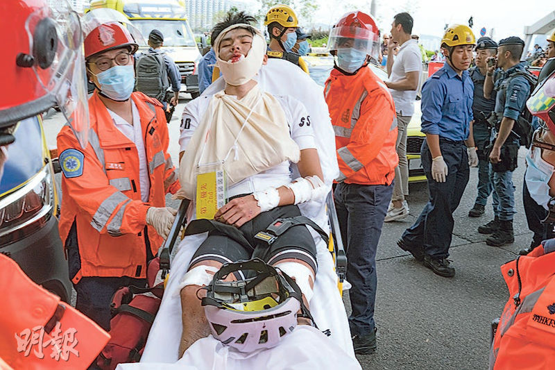 昨早舉行的男子公路組競賽項目發生單車連環相撞意外，13名選手受傷，部分傷勢較嚴重，面部及手腳多處受傷，由救護員初步包紮後以擔架牀抬上救護車送院。（鄧家烜攝）