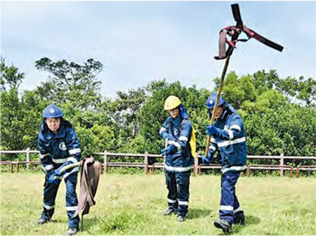 漁護署山火隊員撲救山火時會先用背泵向火源底部射水，其餘兩人就輪流用火拍拍打，以將火救熄。（政府新聞網）