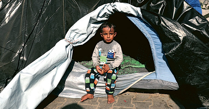 一名巴人兒童昨在汗尤尼斯一處聯合國學校內的帳篷避難。以軍近日呼籲加沙民眾從汗尤尼斯撤往更南面的接壤埃及城市拉法。（路透社）