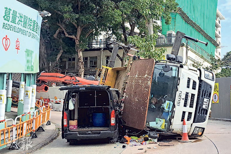 涉事吊臂貨車向右翻側，幾乎緊貼地面，左方兩支「支重腳撐」朝天，右邊則未見腳撐伸出。（衛永康攝）