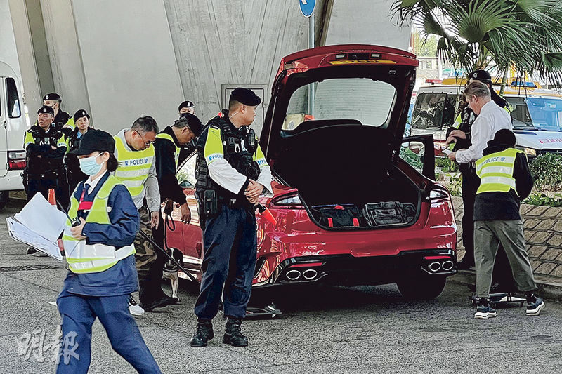 昨日有私家車駛入西九龍法院大樓停車場前，由警員檢查車底和車尾箱。（楊志權攝）