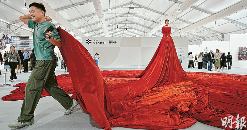 日本藝術家砂山典子的《むせかえる世界》（A Sultry World）是今屆Art Central的「表演藝術」項目。該表演一九九五年在日本一個展覽首次亮相，近30年在世界各地上演；表演者登上巨型猩紅色裙襬裝置，觀眾可進入裙下空間，意念是模糊公共與個人空間，探討人類慾望、倫理和社會規範。昨有不少參觀者走進裙下，進出時略顯狼狽。（賴俊傑攝）