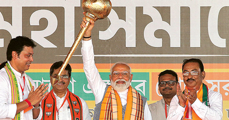 印度總理莫迪（中）周三在特里普拉邦城市阿加爾塔拉出席競選活動時高舉金色「權杖」。（路透社）