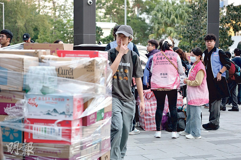 市民連日在東昌街體育館庇護中心外設立物資站，統籌由民間自發送到災場的物資，並有義工協助分發。記者亦見到有關愛隊成員在場（粉紅色衫者）。（蘇智鑫攝）