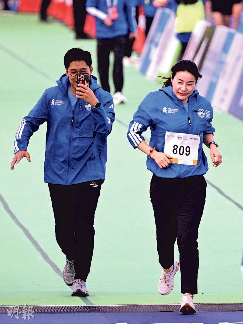 立法會議員霍啟剛(左)昨日與太太郭晶晶參加渣馬「領袖盃」賽事,霍衝線前突然停步,原來是為了舉起手機拍下太太衝線一刻。(曾憲宗攝)
