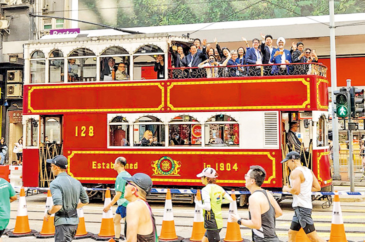 一眾來港出席法律年活動嘅外地律師會代表,噚日搭電車遊覽,當時渣打馬拉松仲跑緊。(律師會提供)