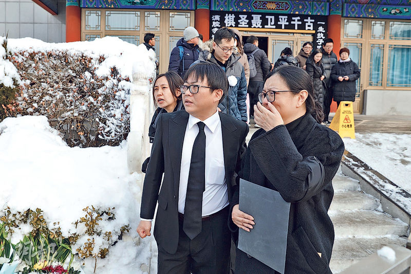 聶衛平長子孔令文(前左)昨日與弟弟妹妹們到八寶山送別父親,家人難掩悲傷。(中新社)